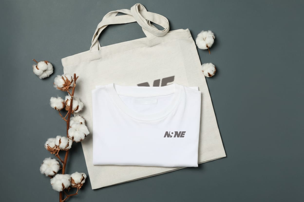 Sustainable cotton tote-style eco-garment bag with folded white t-shirt and natural cotton decor.