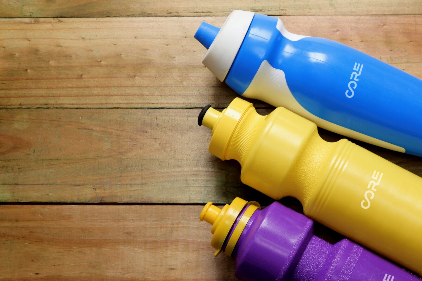 Plastic Water Bottles on Wooden Background for custom drinkware