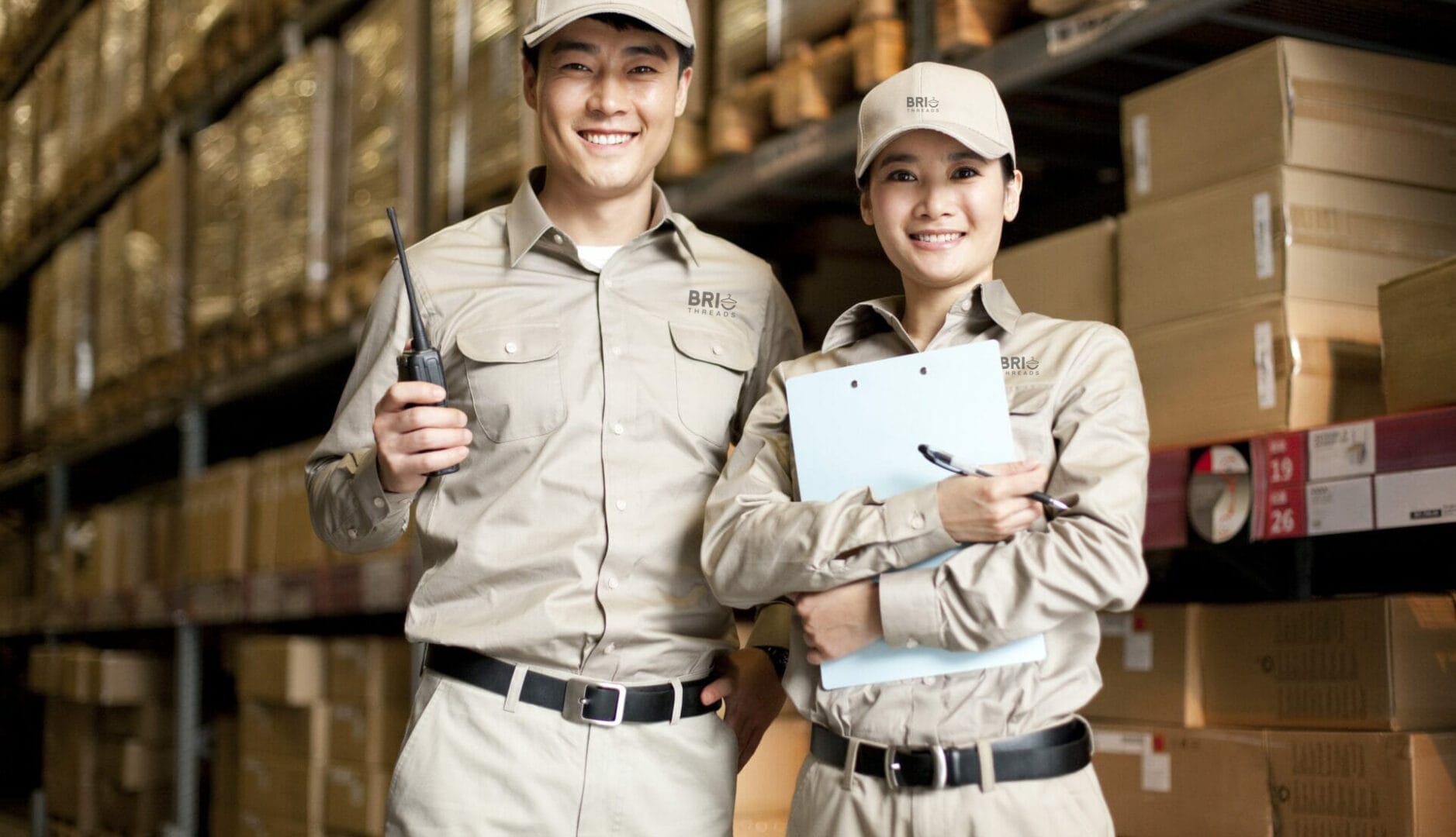 Male and female Chinese warehouse workers in full work uniform