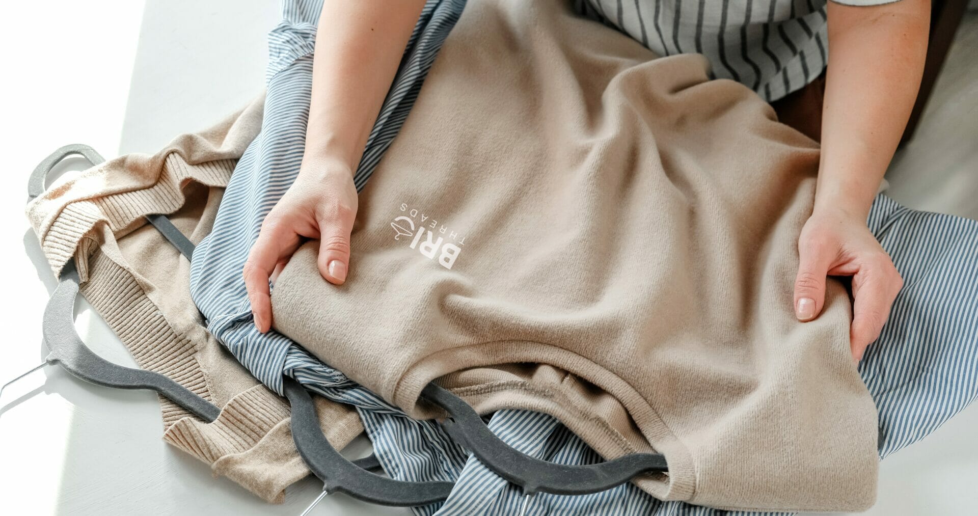 neutral-toned clothing with a visible “BRI Threads” logo, representing eco-friendly apparel