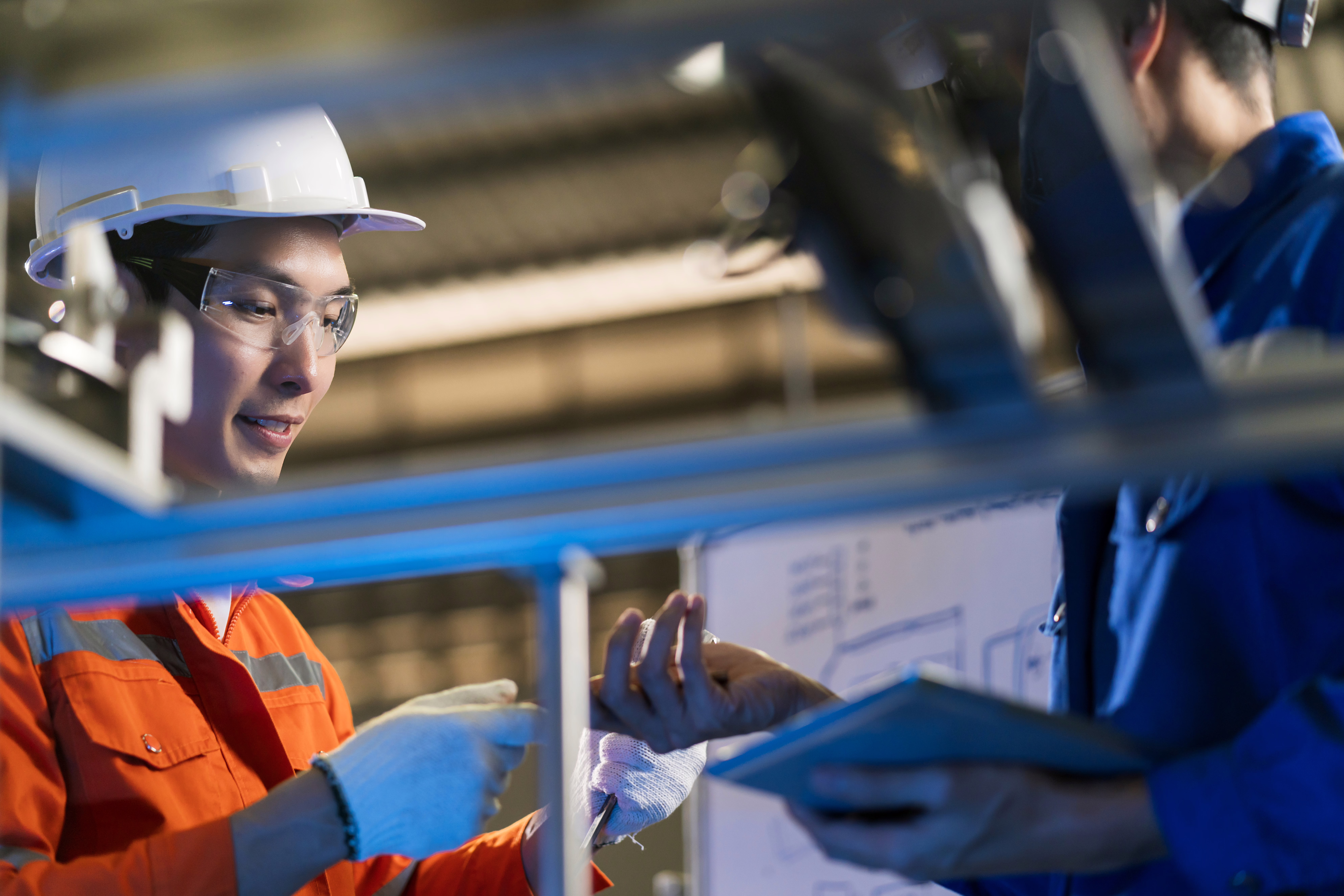 male-asian-engineer-professional-having-discussion-standing-by-machinefactory-